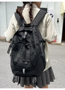Detailed back view of a black nylon backpack with mesh pockets and safety reflective strips