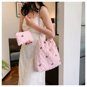 Pink quilted polyester tote bag with black bow embroidery and silver chain strap details