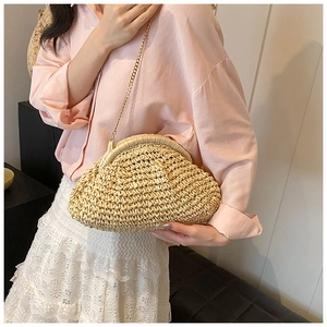 Close-up of woven straw texture and gold chain on beige crossbody summer bag