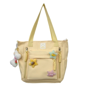 Fashionable nylon shoulder bag in pale yellow featuring cute 3D star patches and plush charm
