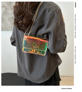 Detailed view of iridescent laser crossbody bag with gold chain strap on a model