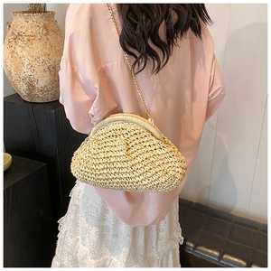 Detailed texture of beige straw crossbody cloud bag with elegant gold chain strap