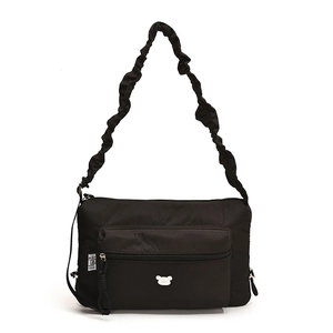 Minimalist black nylon crossbody bag with ruffled strap and bear emblem on white background