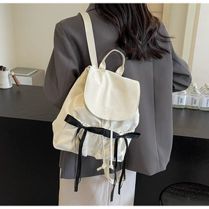 Detail view of cream PU leather backpack with black bows and NiKa embroidery for women