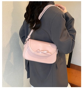 Dettaglio della borsa in pelle PU rosa chiaro con fiocco 3D e tracolla regolabile