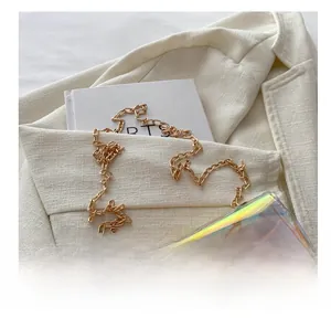 Detailed close-up of a holographic crossbody bag with gold chain strap and metallic lock