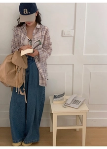 Lifestyle view of a vintage nylon backpack paired with a casual checkered shirt and jeans