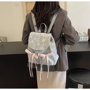 Detail of silver velvet backpack with marble texture and pink silk bow decorations