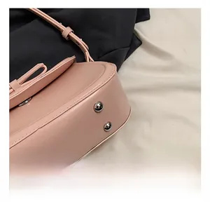 Dettaglio della borsa in pelle PU rosa con borchie metalliche e cuciture rifinite