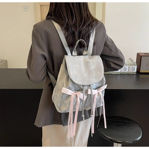 Detail of silver PU backpack with Nika embroidery and pink ribbon bow accents