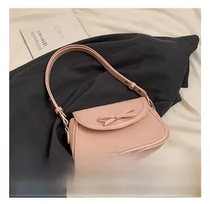 Dettaglio borsa a tracolla rosa in pelle PU con fiocco decorativo e borchie in metallo