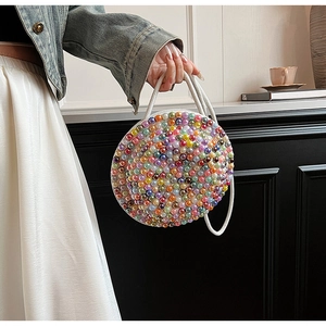Dettaglio di una borsa a tracolla rotonda in cotone e lino con perle finte colorate
