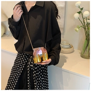 Detailed view of pink iridescent crossbody bag with unique fluid shape and gold chain