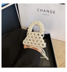 Close-up of handmade faux pearl woven mini bag with elegant chain and carry handle