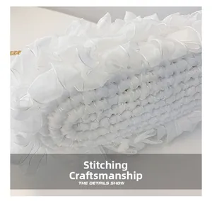 Macro shot of precise stitching craftsmanship and white organza ruffles on fabric bag