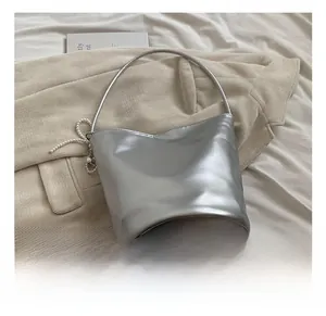 Detail of silver PU bucket bag with metallic finish, pearl chain and metal sphere pendant