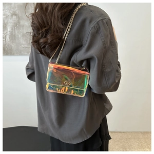 Detail view of the iridescent holographic PVC material and golden metal chain strap of the bag