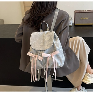 Silver metallic backpack with pink ribbon bows and Niki embroidery details