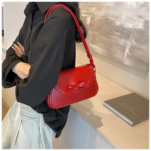 Dettaglio della borsa a tracolla in pelle PU rossa con fiocco elegante e cuciture fini