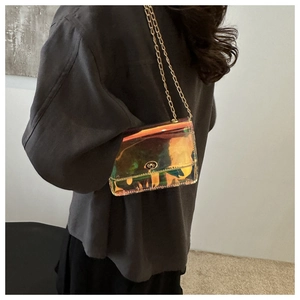 Detailed view of the holographic laser chain bag worn on shoulder by a model
