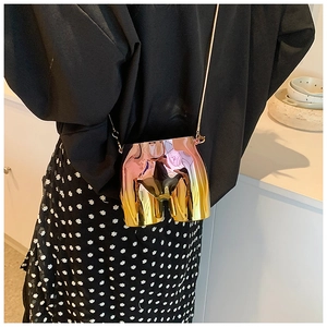 Detail view of the iridescent torso-shaped crossbody bag with gold chain strap