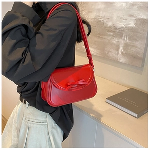 Dettaglio della borsa a tracolla in pelle PU rosso vivace con fiocco su una modella