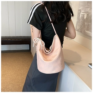 Detail of pink PU shoulder bag with decorative white pearls and shimmering leather texture
