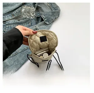 Detail view showing internal storage capacity of quilted beige crossbody phone bag