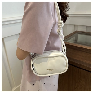Detail of white PU crossbody bag with unique chunky chain strap and knotted accents
