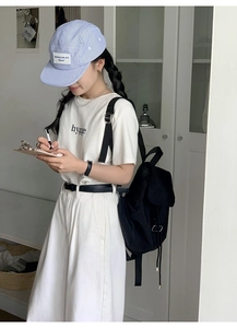 Minimalist black nylon drawstring backpack shown in a trendy casual lifestyle setting