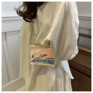 Detail of small holographic crossbody bag with golden metal lock and metallic chain strap