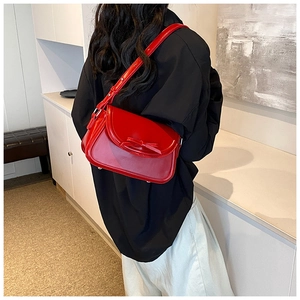 Dettaglio della borsa a spalla rossa in ecopelle con fiocco indossata da una modella