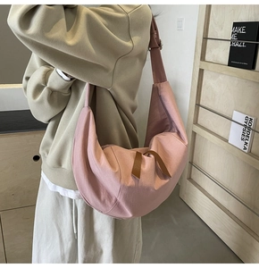 Detail view of pink crescent nylon crossbody bag with stylish leather zipper pulls