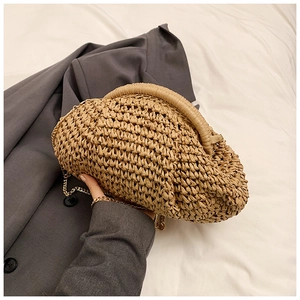Minimalist straw woven crossbody bag with round handle and gold chain strap in natural tan