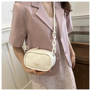 Detail of white PU leather crossbody bag with chunky chain strap and gold logo