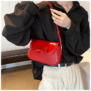 Dettaglio della borsa a spalla in pelle PU rossa con fiocco elegante e tracolla regolabile