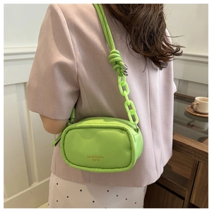 Model wearing a bright neon green PU leather crossbody bag with chunky acrylic chain