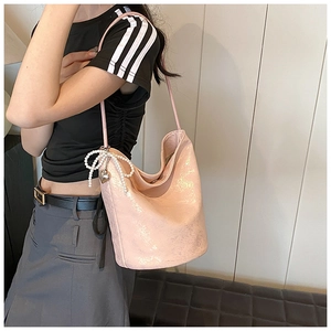 Detailed shot of pink metallic Hobo bag with pearl bow charm and heart pendant