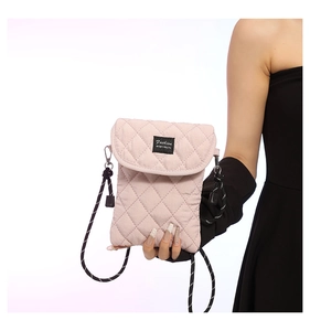 Detail of light pink quilted nylon mini phone bag with black Fashion label and rope strap