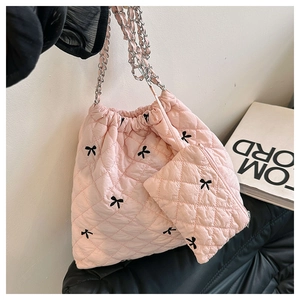 Pink quilted backpack with black bow pattern, metal chain strap and matching mini coin purse