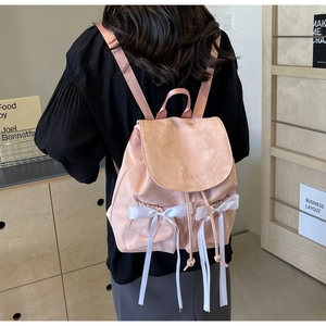 Detailed back view of pink drawstring backpack with white silk bows and NiKa embroidery