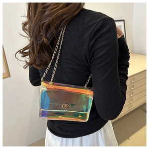 Detail of holographic PVC crossbody bag with golden chain strap and twist lock