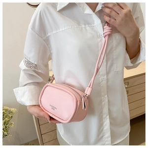 Close-up of pink PU leather crossbody bag featuring a unique knotted shoulder strap detail
