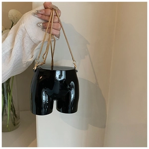 Detail of artistic female torso crossbody bag in glossy black with gold chain