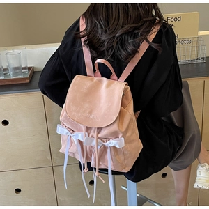 Close-up of pink PU backpack featuring a white ribbon bow and NiKa logo detail