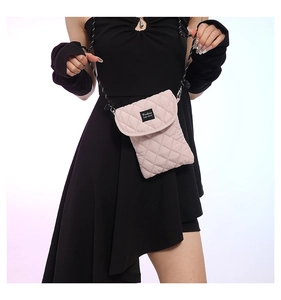 Detail of pink quilted crossbody phone bag with fashion label on the front flap