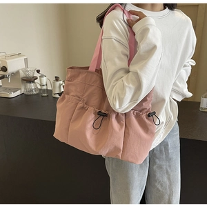 Seitenansicht der rosafarbenen Stofftragetasche mit praktischen Kordelzugtaschen