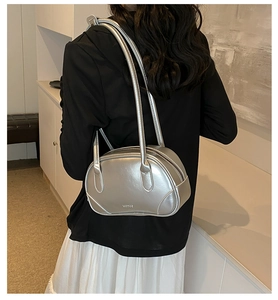 Detailed close-up of metallic silver PU leather shoulder bag with sleek long straps