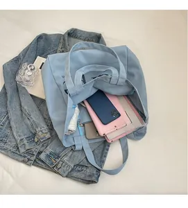 Macro shot of spacious interior in light blue canvas tote bag with multiple items