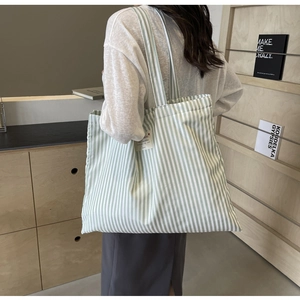 Detailed view of striped canvas tote bag with light green and white vertical lines